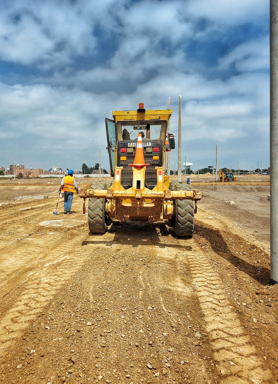 yellow heavy equipment grading a dirt road